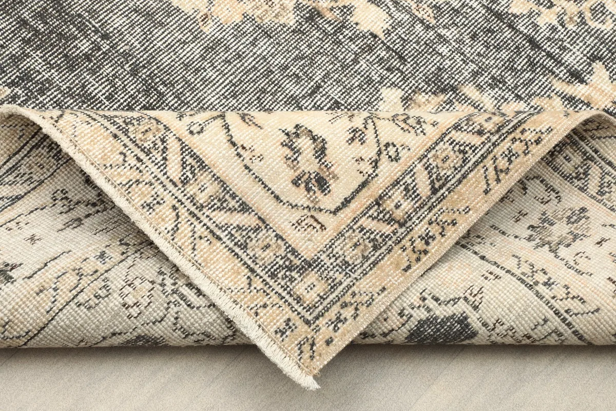 Folded corner of the rug revealing the cotton foundation and reverse side