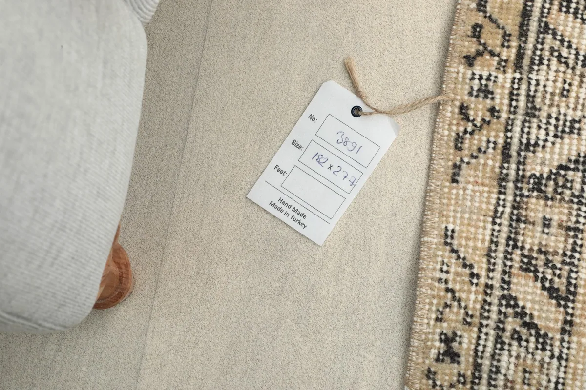 Product tag indicating the rug's hand-made origin and dimensions