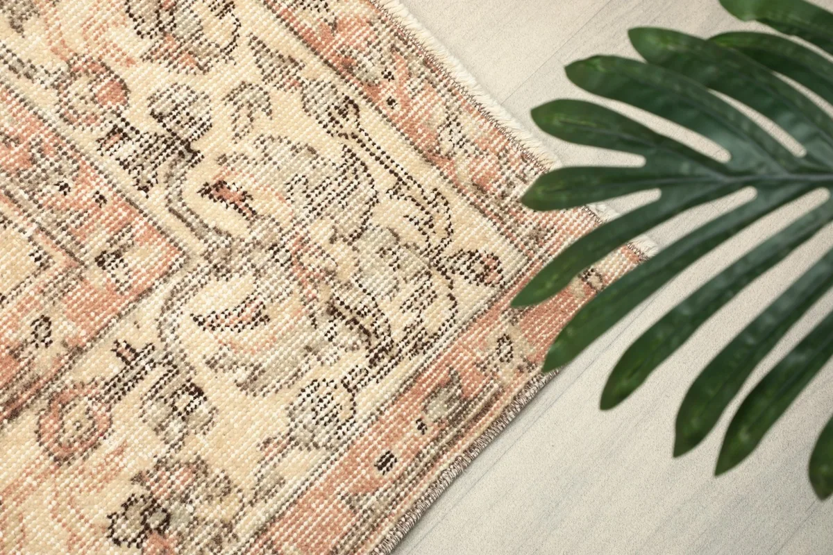 Angled view of the rug's pattern with a green plant in the foreground