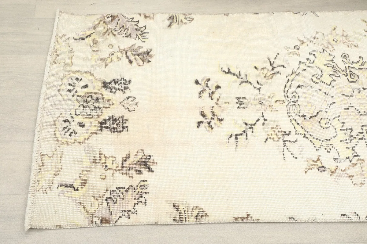Close-up angled view of the rug's end, showing pattern details and patina