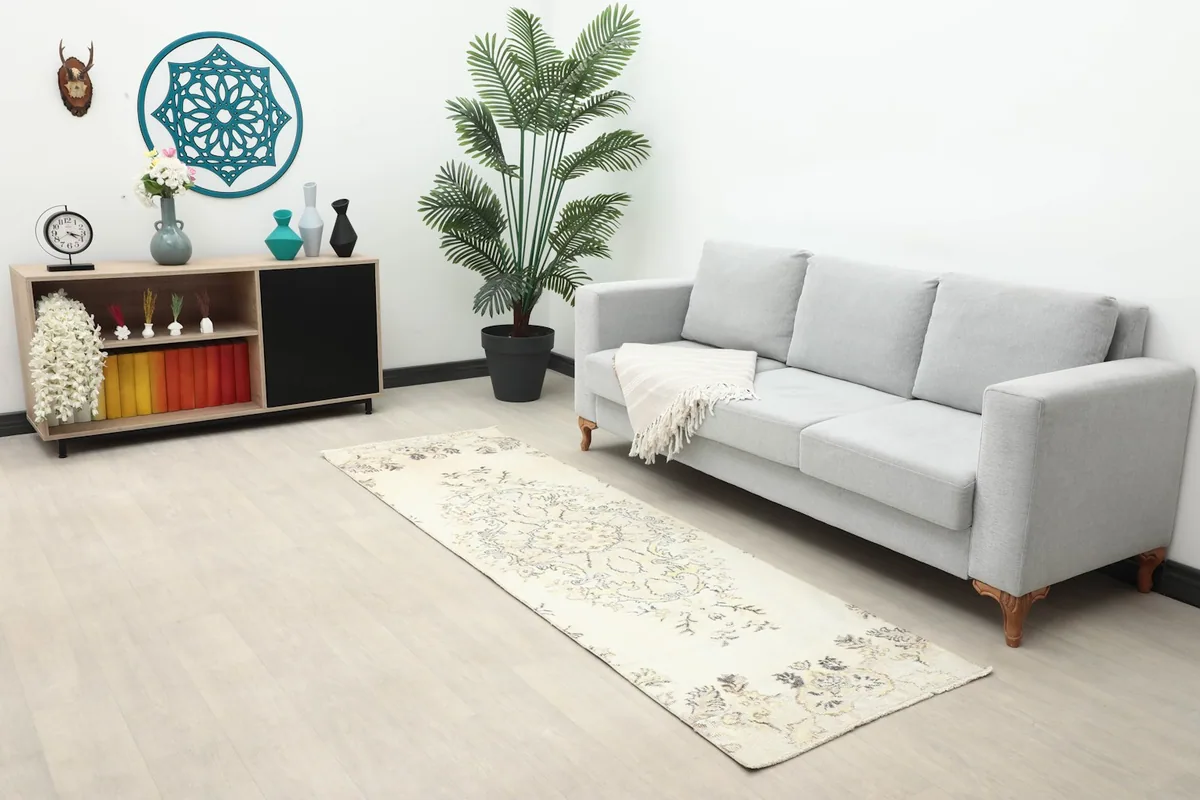 Ivory runner rug displayed in a living room setting with a sofa and console table