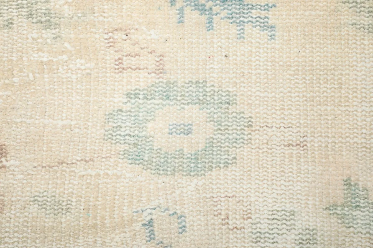 Macro view of the hand-knotted wool pile, showing individual knots and the soft texture of the rug.