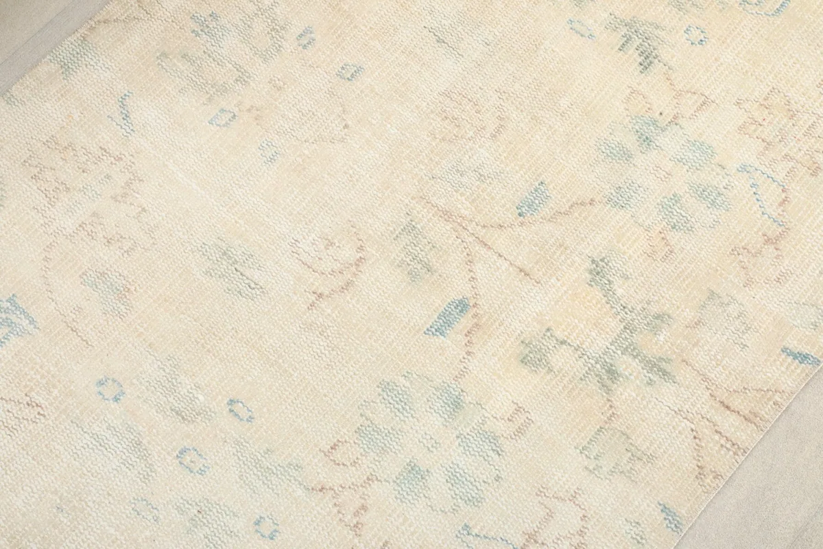 Texture shot of the rug's low wool pile, revealing the distressed look and subtle color variations.