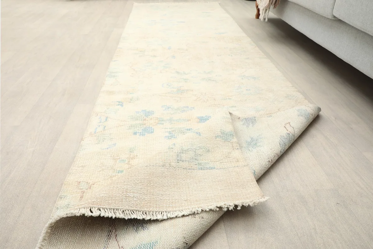 Side view of the runner rug, partially rolled, showcasing its flexibility and the overall length.