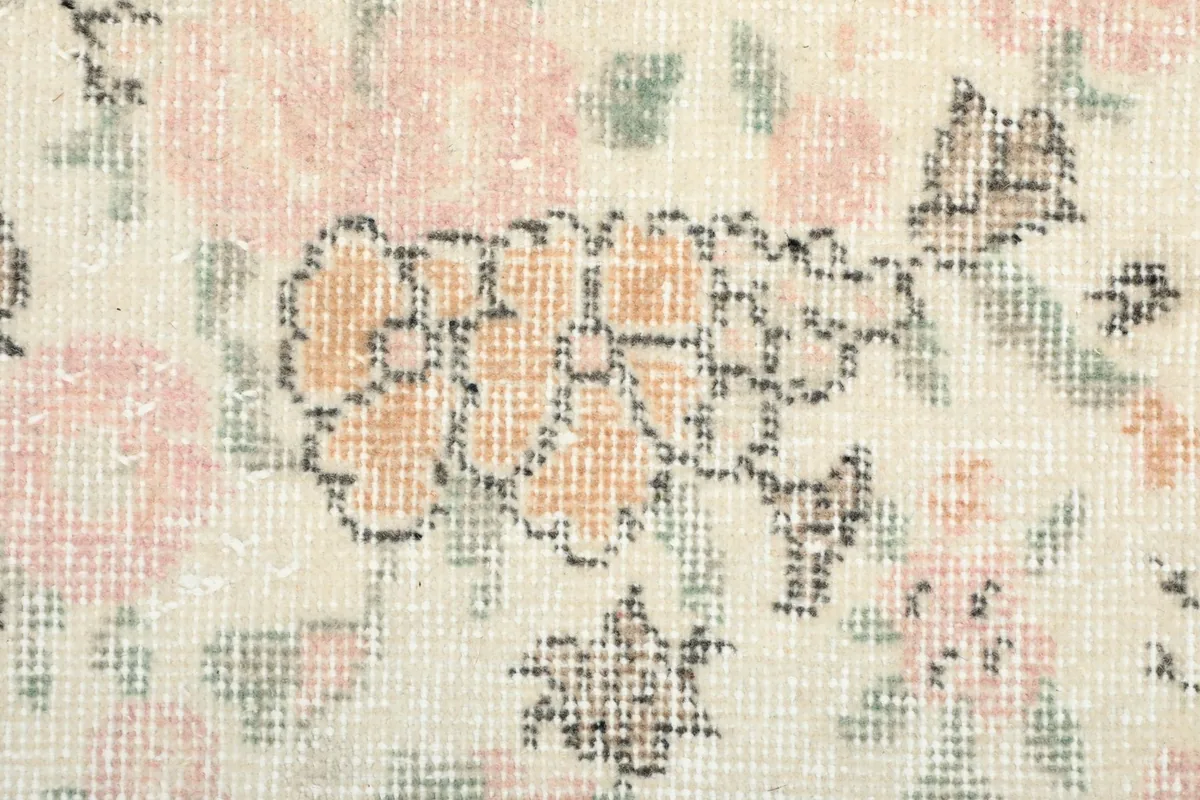 Extreme close-up of the wool pile, showing the hand-knotted texture and individual floral details.