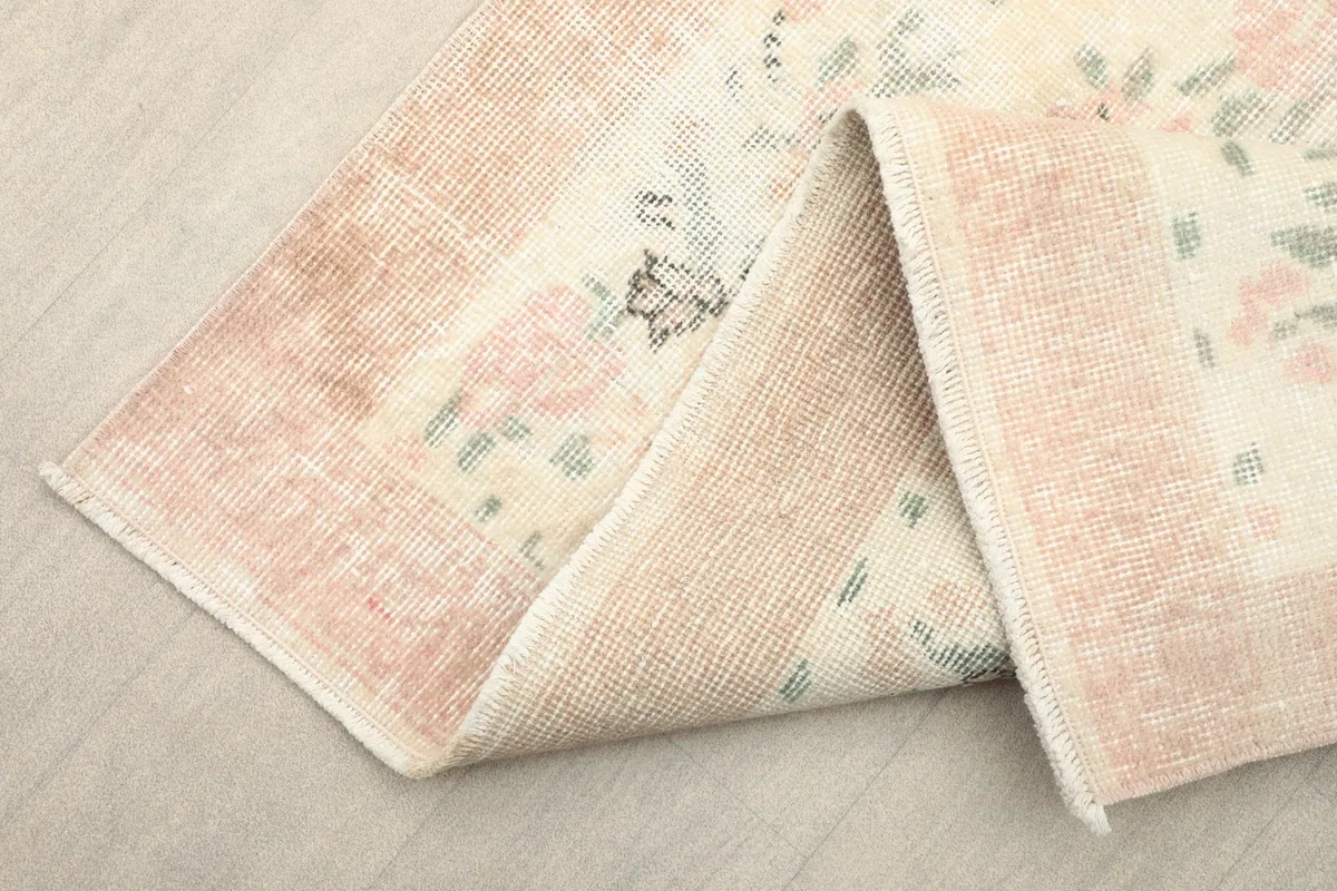 The rug folded to reveal the reverse side, showing the cotton foundation and hand-knotting.