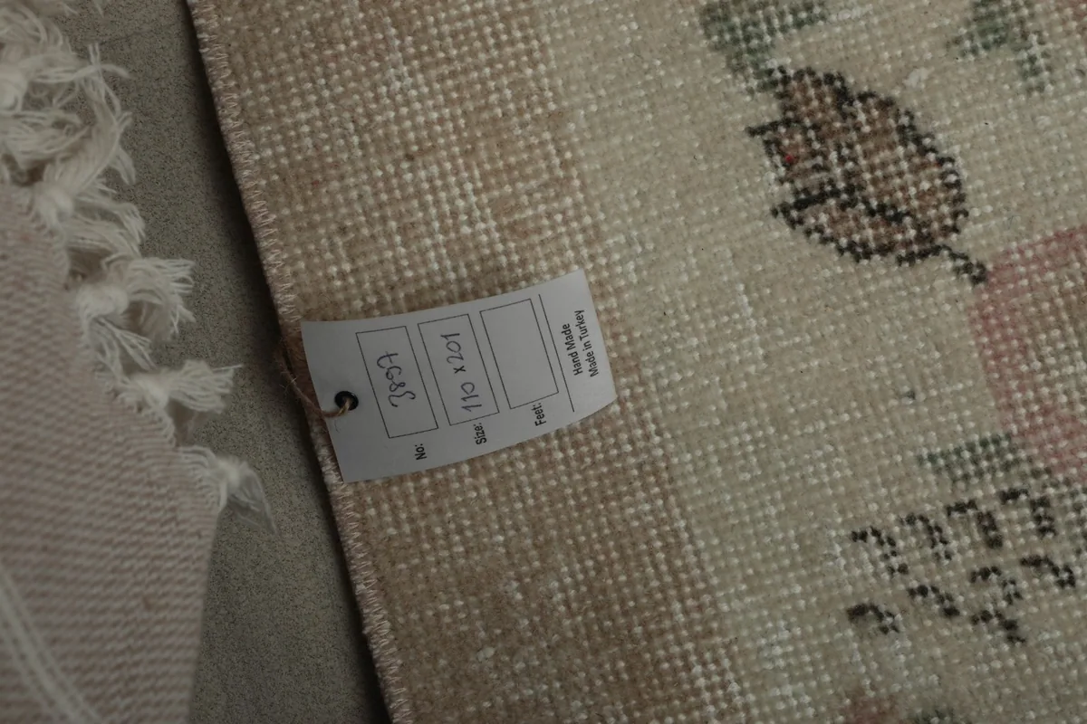 Close-up of the rug's label, confirming its origin and material as a hand-knotted Anatolian wool rug.