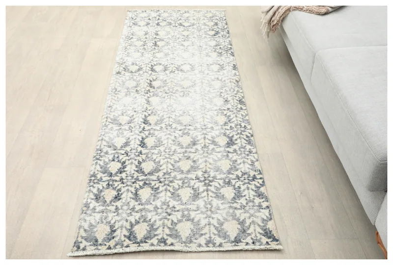 Full top view of the 2'4" x 6'8" ivory and navy vintage runner rug on a white background.
