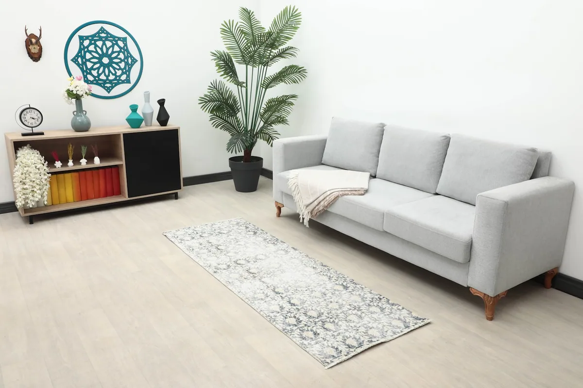 Ivory and navy runner rug placed in a modern living room setting with a light gray sofa and wooden floor.
