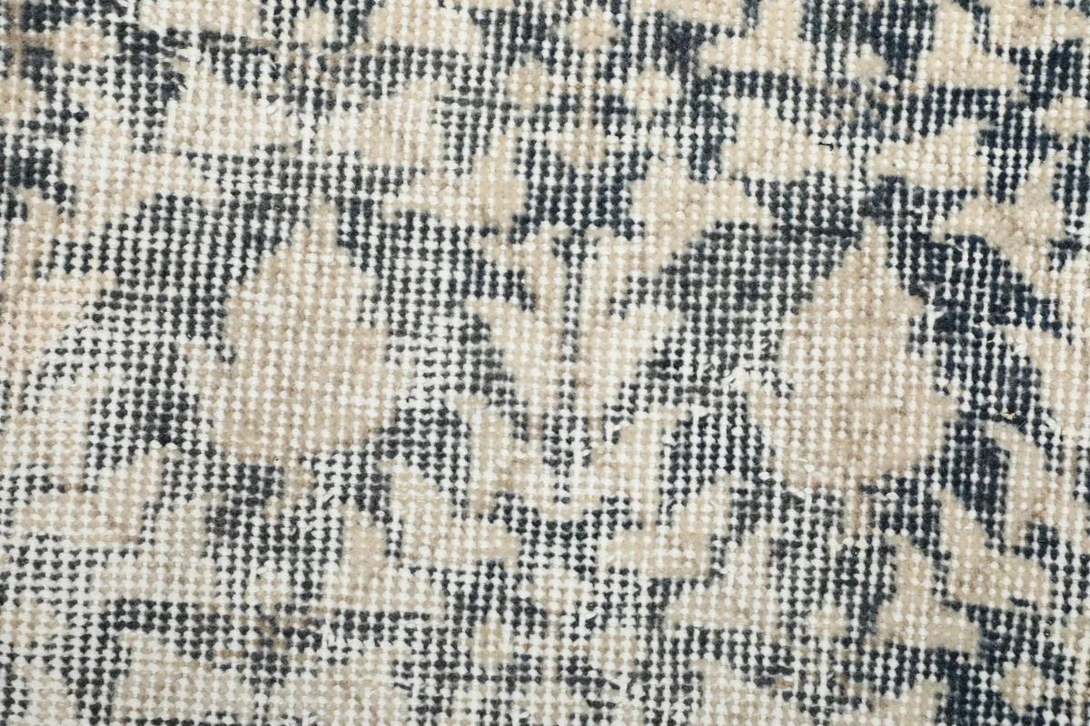 Extreme close-up showing the low wool pile and the hand-knotted structure of the rug.