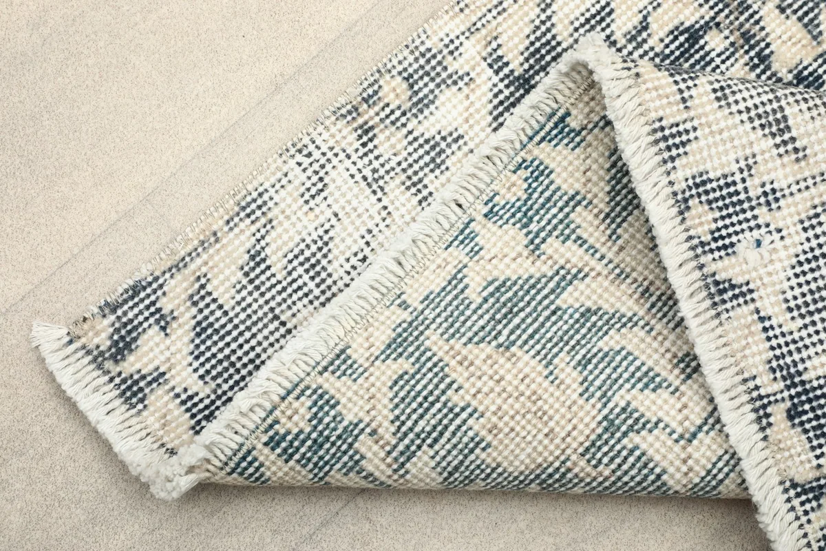 View of the back of the runner rug, revealing the cotton foundation and knotting detail.