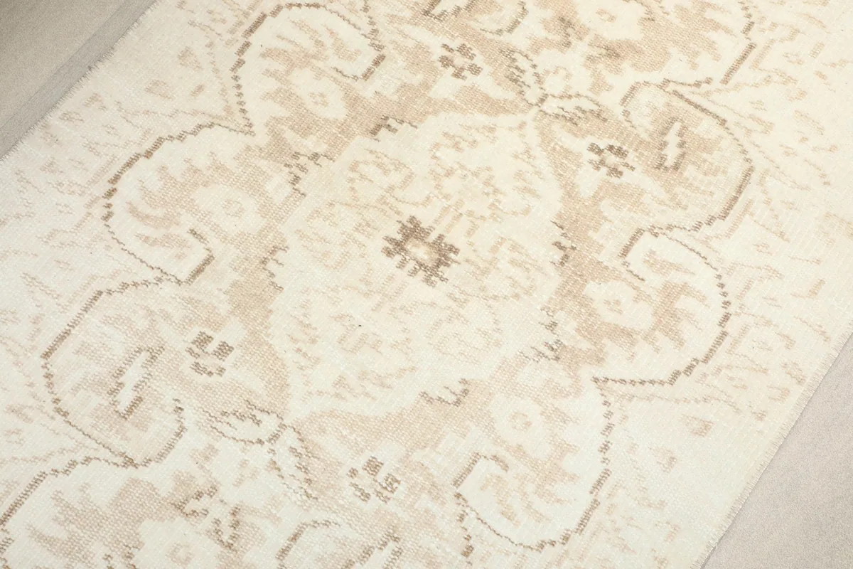 Close-up on the central medallion motif in shades of ivory and tan