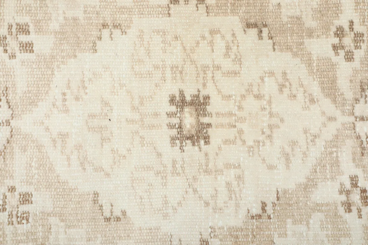 Texture shot showing the low wool pile and hand-knotted weave of the rug