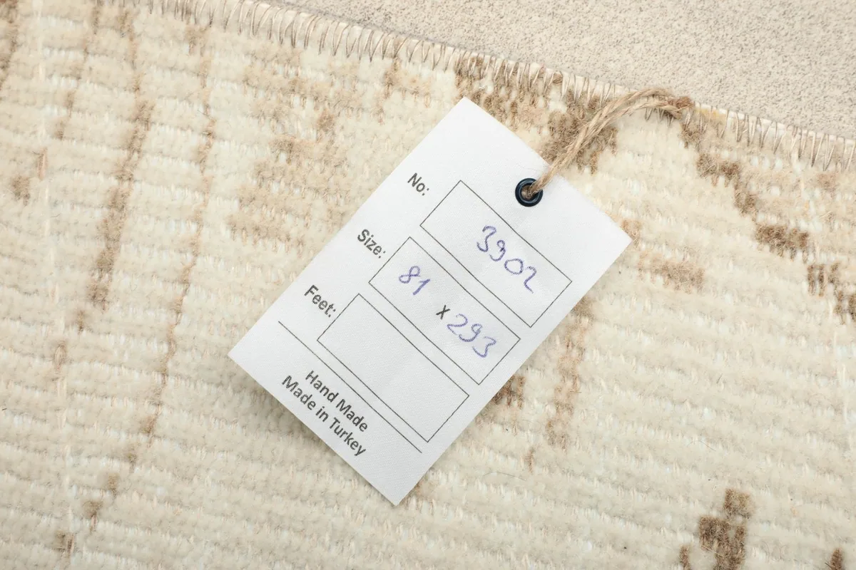 Product tag on the rug showing its dimensions and handmade origin from Turkey