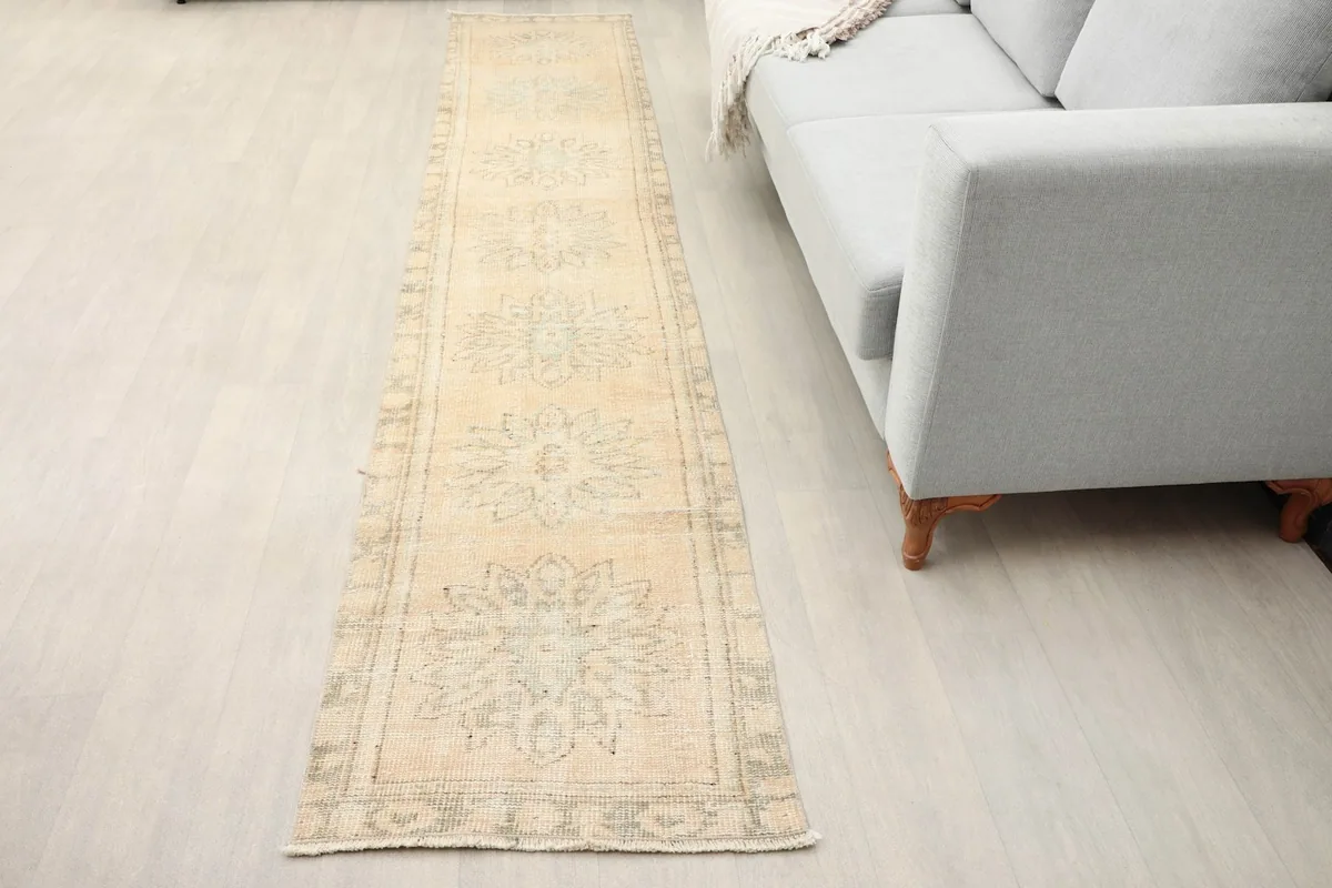 Vintage Anatolian runner displayed in a modern living room setting next to a light gray sofa