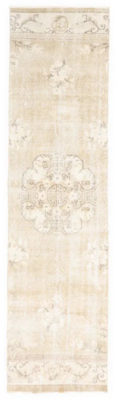 Full overhead view of the beige floral medallion Anatolian runner rug on a white background.
