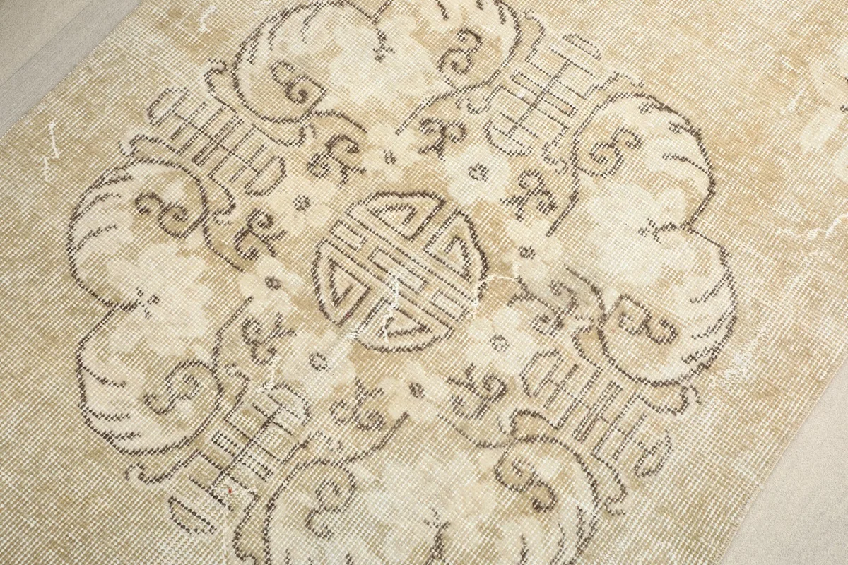 Close-up of the central medallion design on the beige runner rug, showing intricate geometric details.