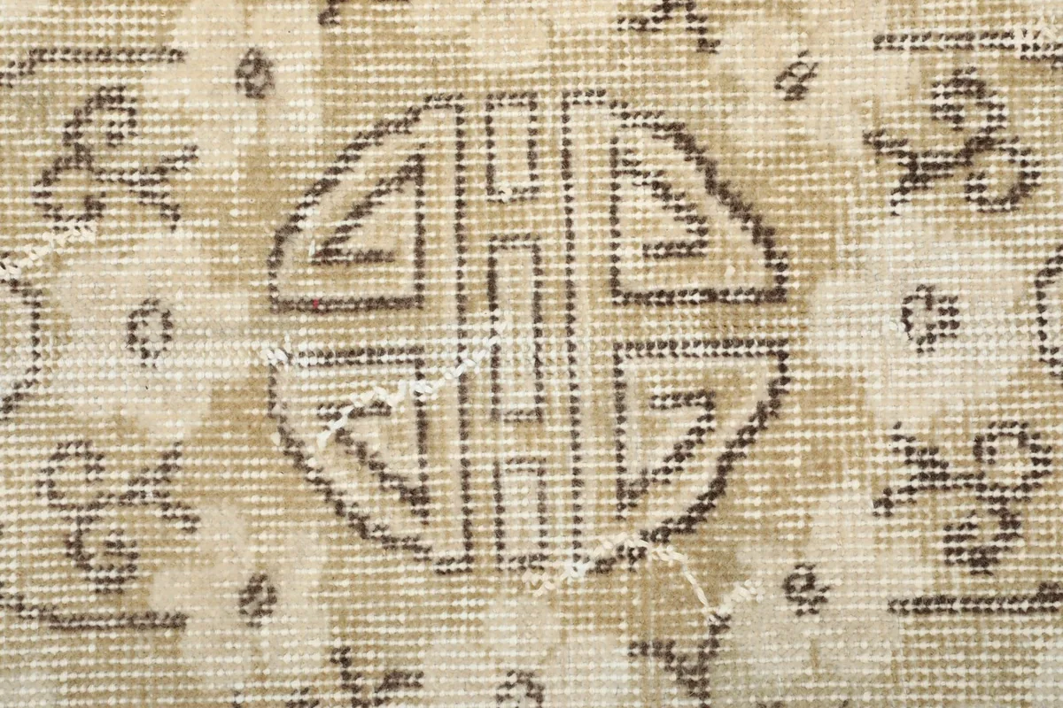 Extreme close-up of the central motif, revealing the hand-knotted wool pile and weave structure.