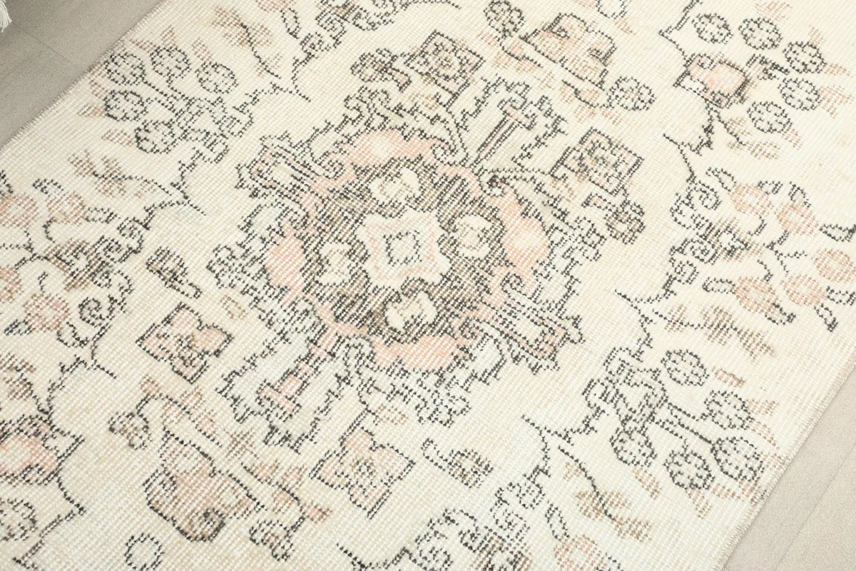 Close-up of the central medallion motif with rose and gray accents on the rug