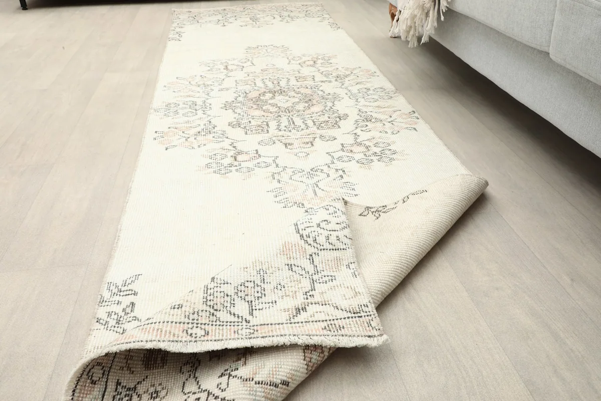 Corner of the runner rug gently folded, highlighting the texture and design