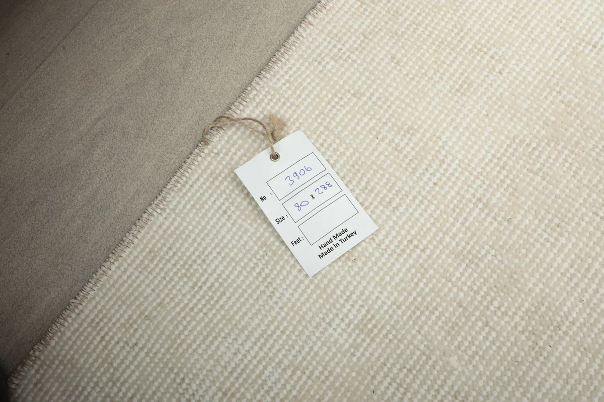 Close-up of the back of the rug with a size tag showing 3x9 and 80x288 cm