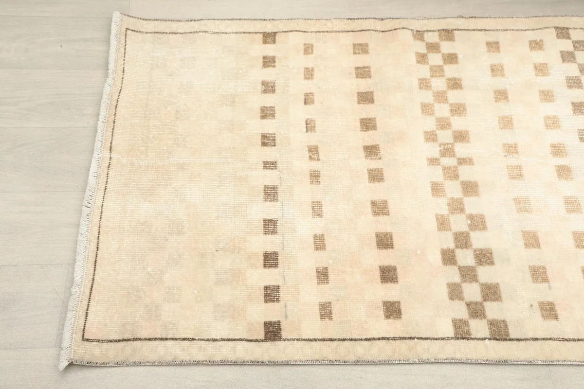 Angled view of the runner's end, highlighting the subtle border and geometric pattern
