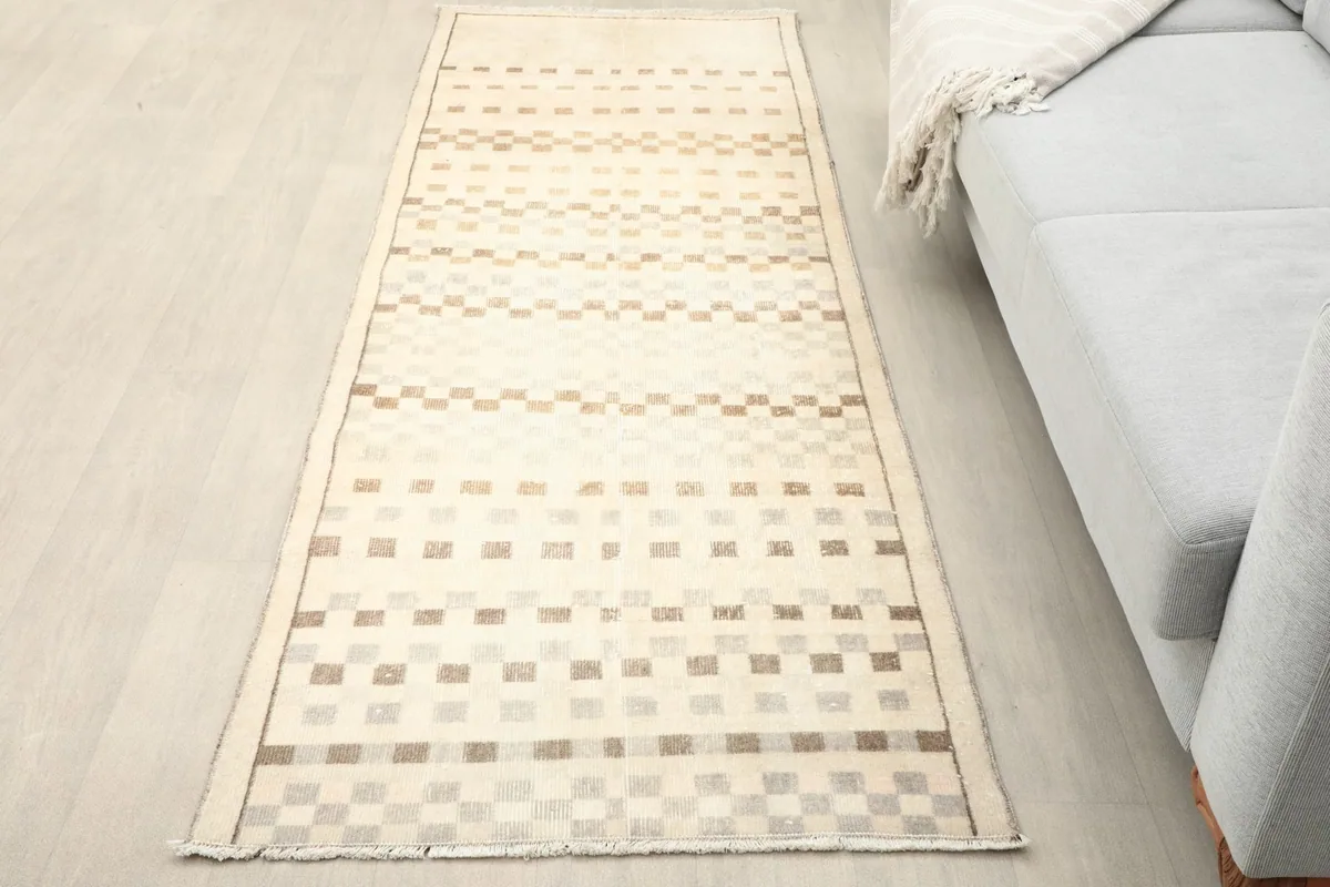 Overhead view of the beige and brown geometric runner placed on a light floor next to a sofa