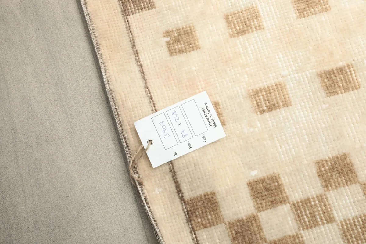 Close-up of the rug's edge with a tag, showing the intricate hand-knotting