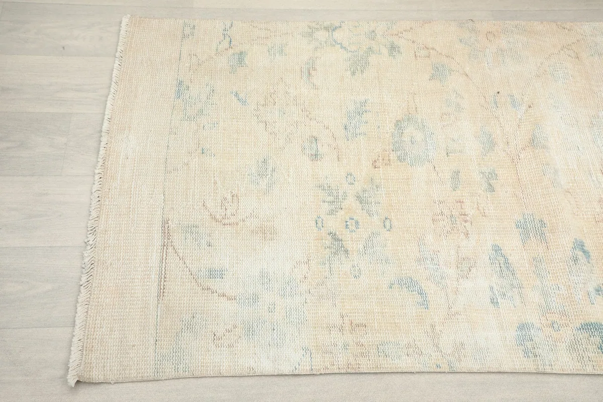 Detailed view of the rug's edge, showing the hand-knotted wool pile and cotton foundation.