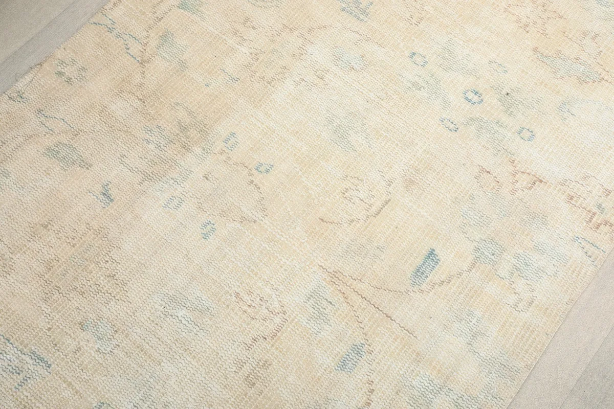 Overhead detail of the rug's surface, highlighting the gentle patina and muted colors.