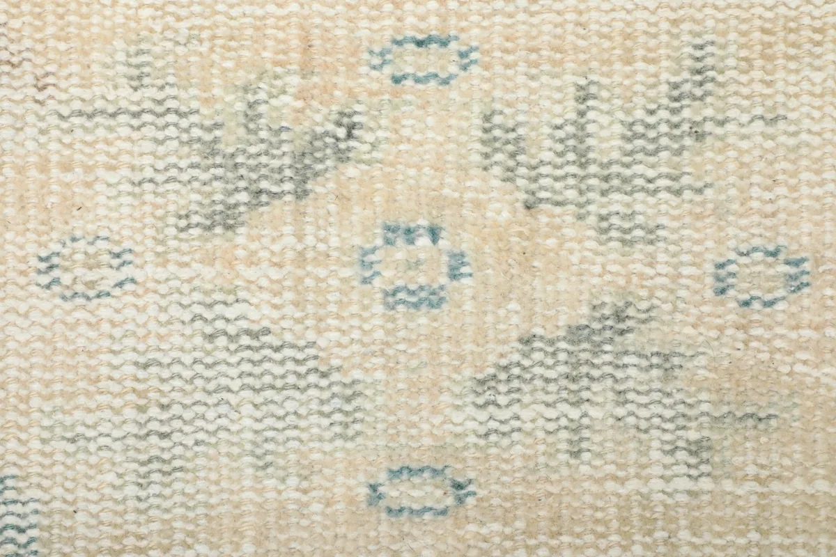 Macro shot of the low wool pile, revealing the texture and subtle geometric patterns.