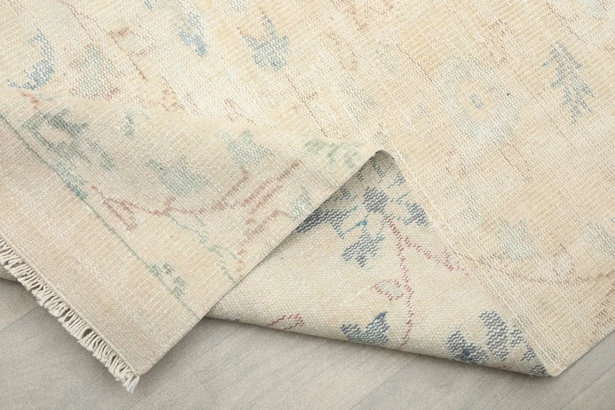 Close-up of a folded section of the rug, showing the intricate details of the motifs.