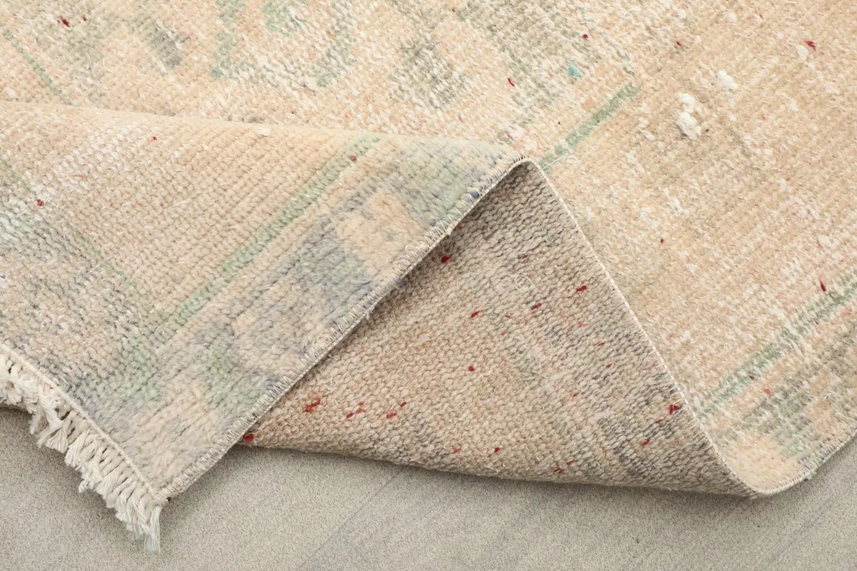 Folded section of the rug revealing the back of the hand-knotted construction and the even cotton foundation.