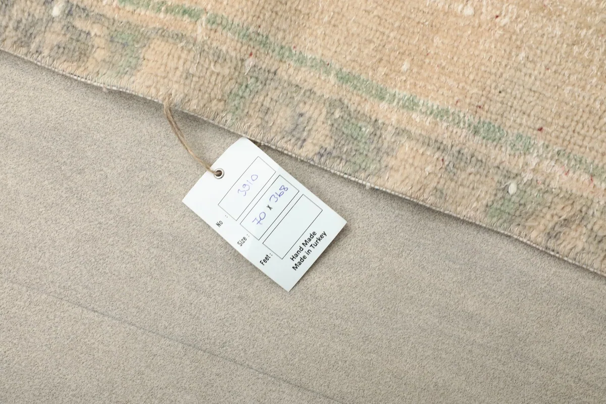 Close-up of the product tag attached to the rug, showing details like size and origin: 'Hand Made in Turkey'.