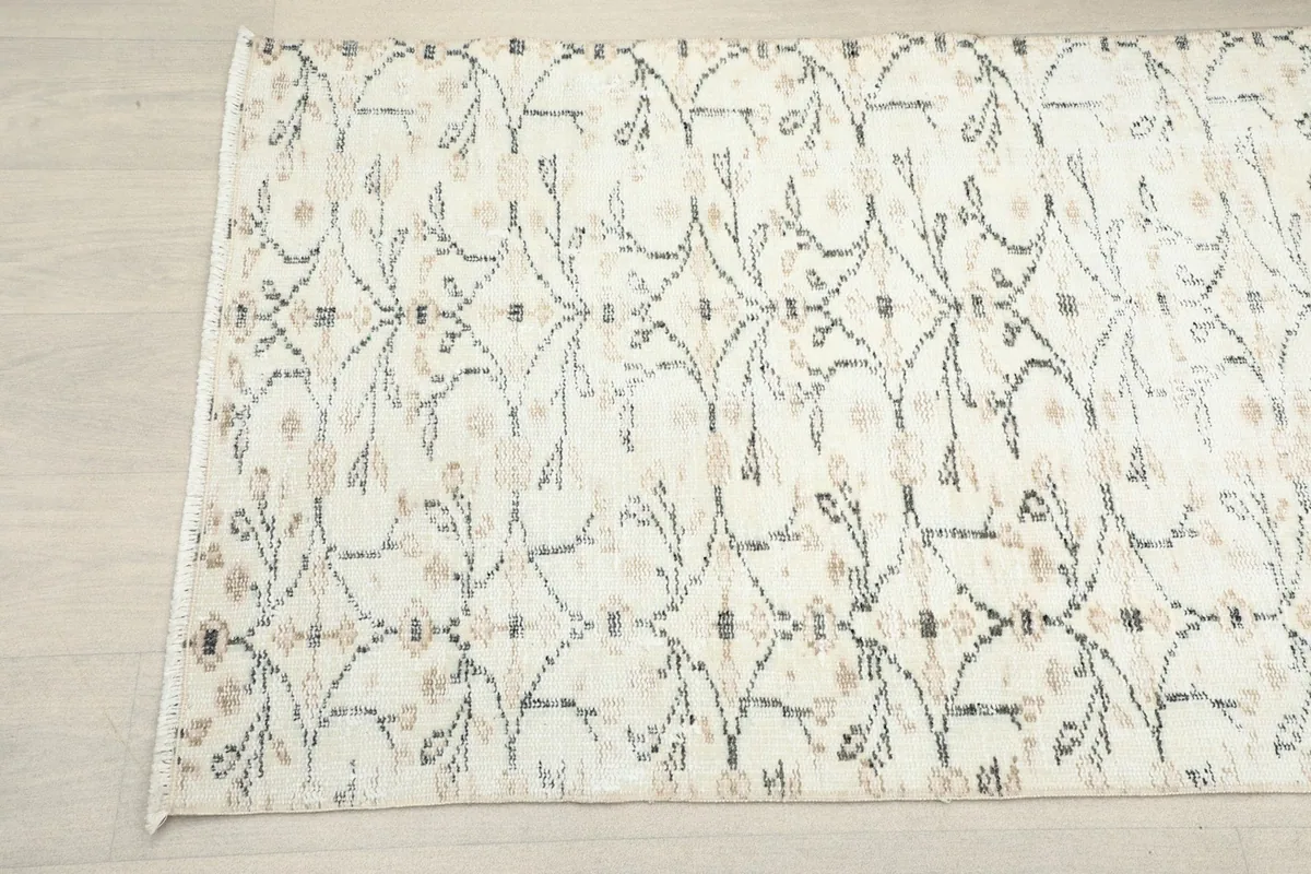 Angled close-up of the ivory runner rug's pattern and subtle color variations.