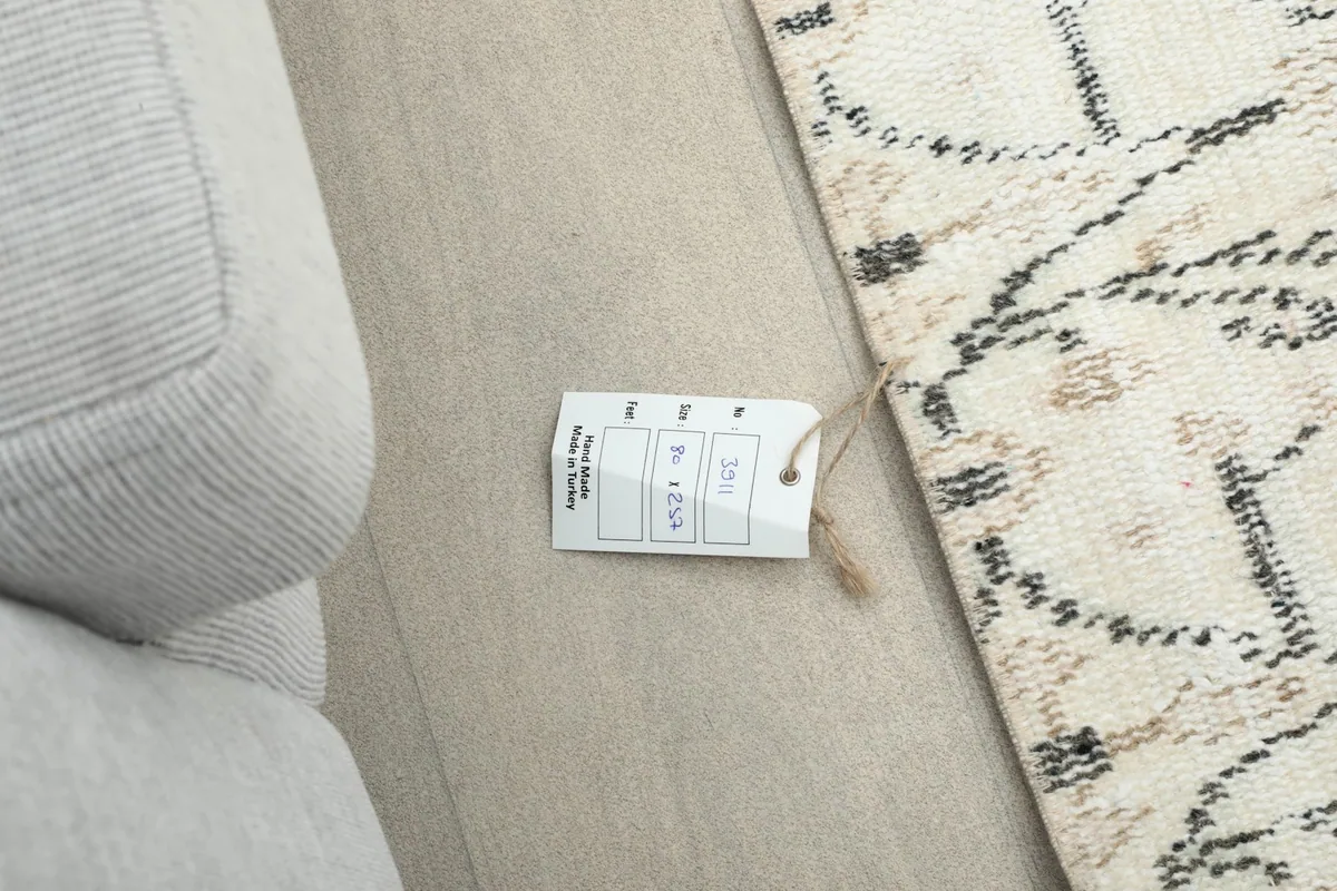 Close-up of the rug's surface next to a sofa, with a product tag visible.