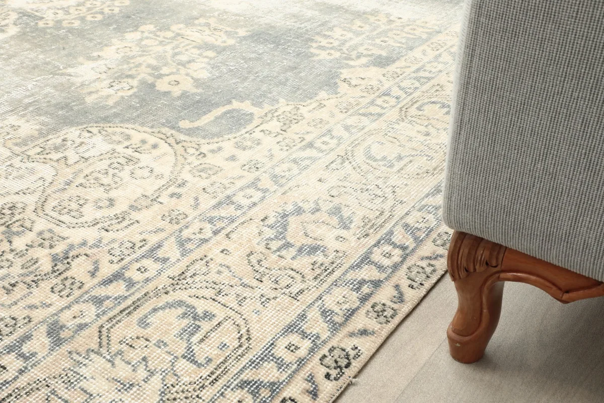 Rug placed next to a sofa leg, showing how the border interacts with furniture