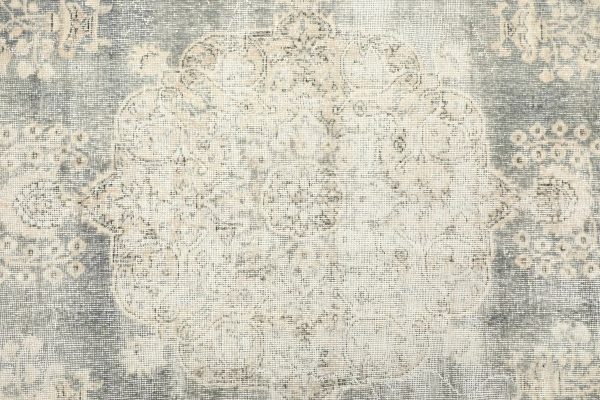 Close-up of the central medallion design on the gray field with ivory motifs