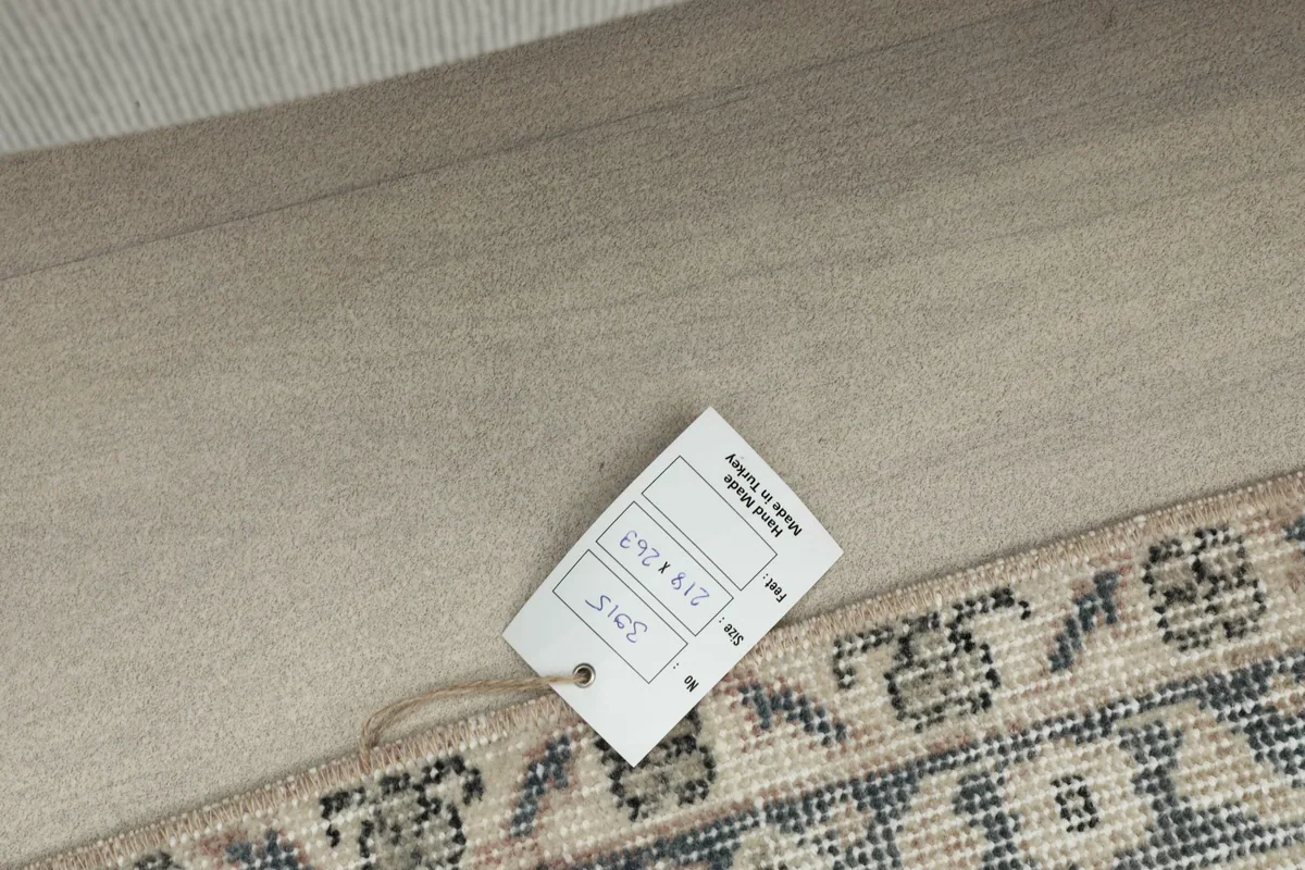 Size label tag attached to the rug corner, displaying dimensions in cm and inches