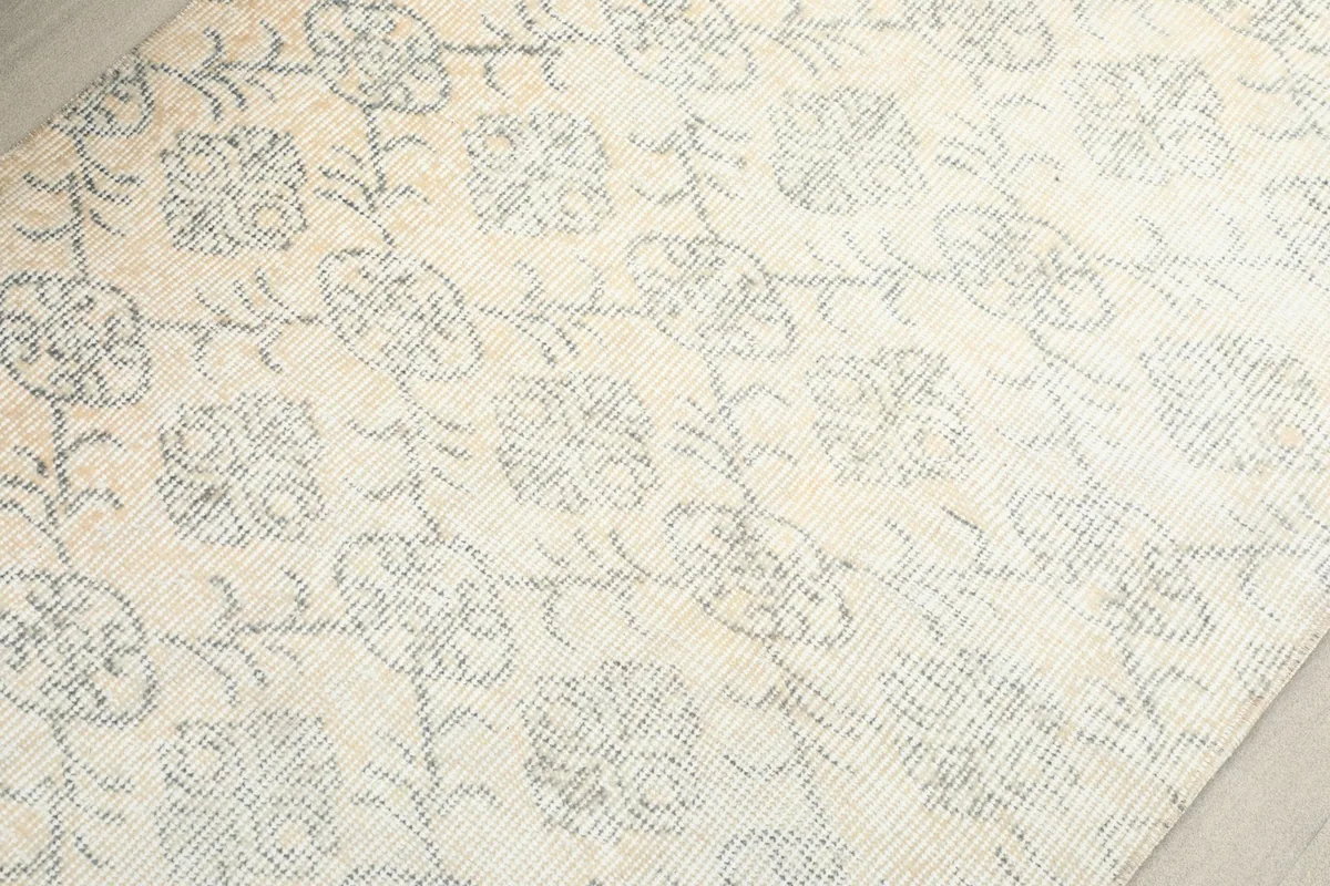 Close-up detail of the hand-knotted wool pile, revealing the intricate geometric and floral design.