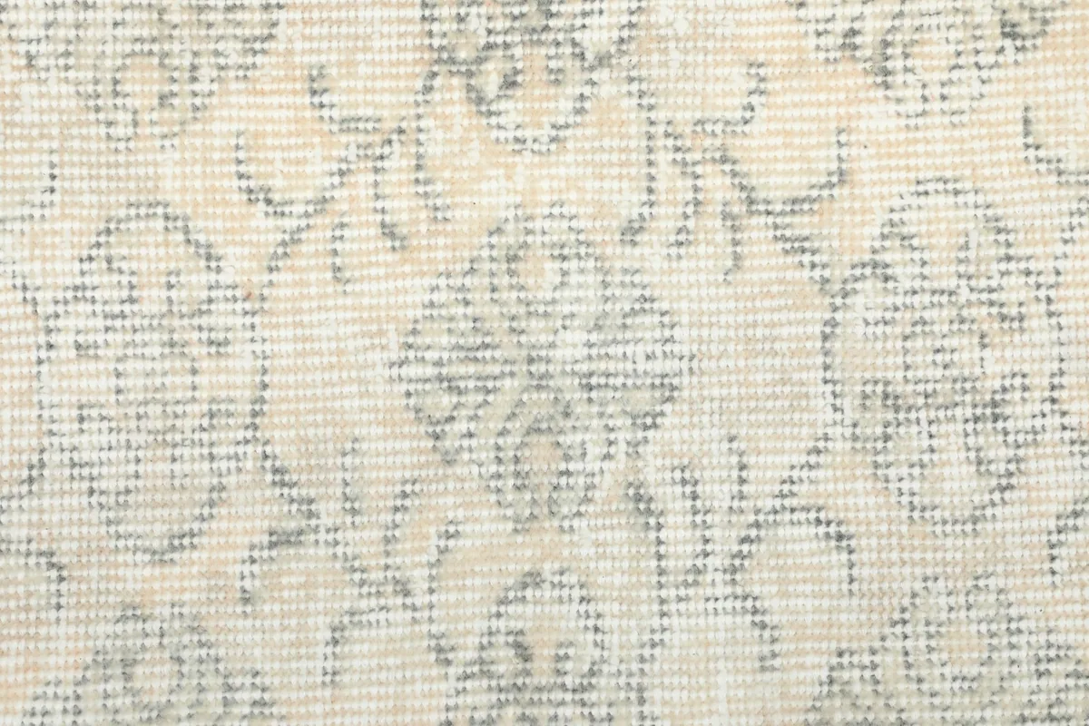 Macro detail of the rug's surface, showing the subtle color variations and texture of the vintage wool.