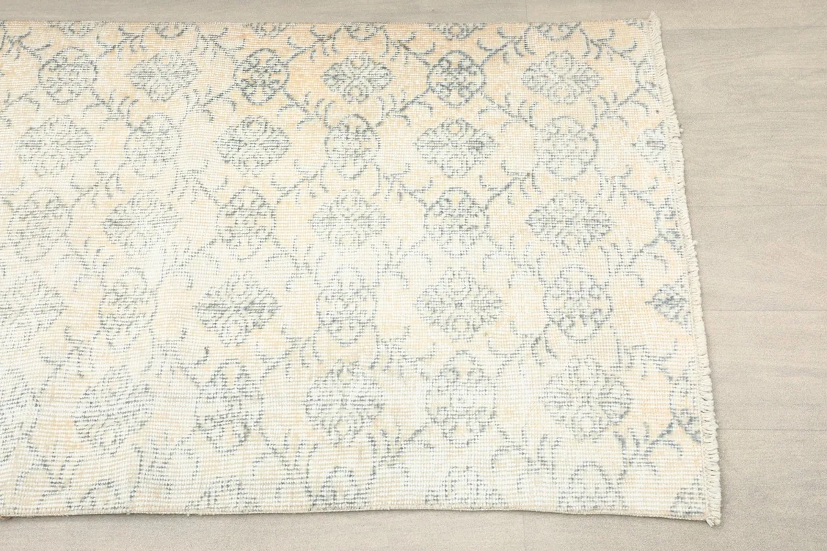 Overhead view showing a section of the runner, focusing on the repeating gray geometric motifs on a cream field.