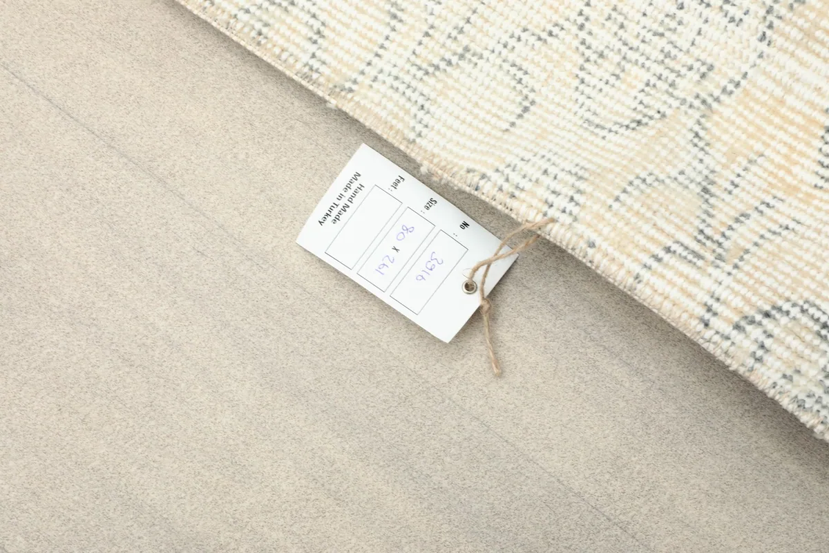 Rug tag attached to the runner, indicating its origin and material, resting on a light surface.