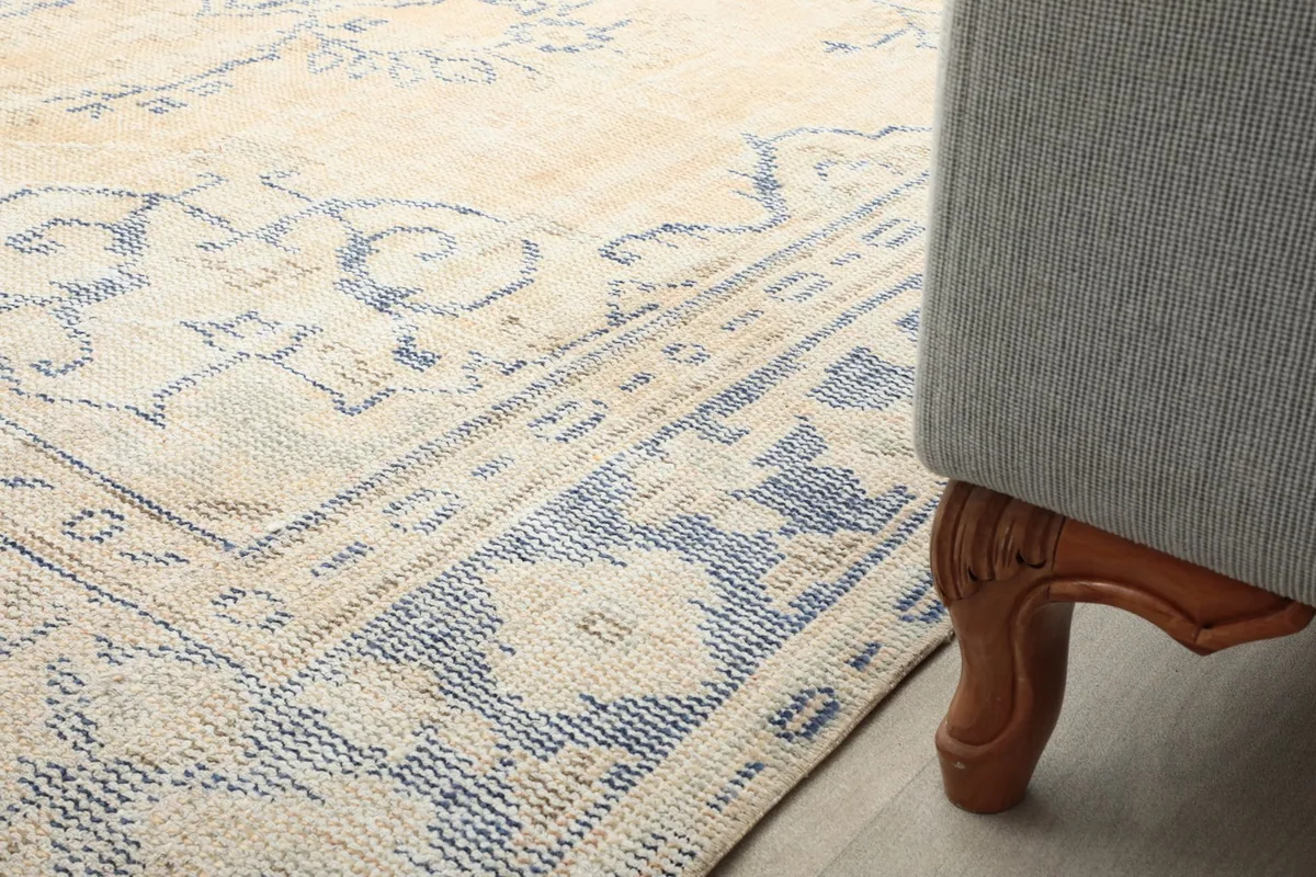 Rug edge next to a sofa leg, showing how the rug complements the room's decor