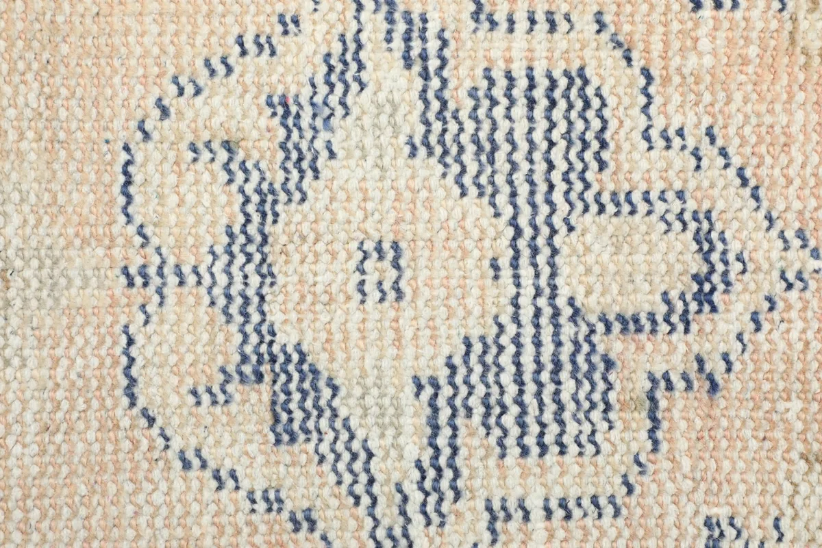 Detailed view of the low wool pile, showing the hand-knotted texture and blue patterns