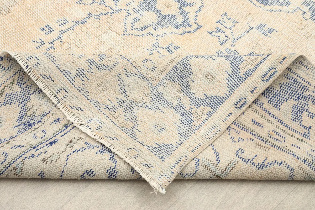 Corner of the rug folded back, revealing the reverse side of the hand-knotted construction