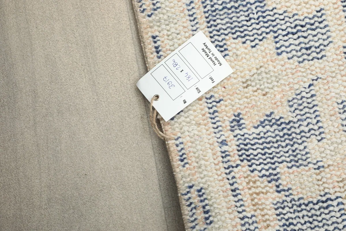 Close-up of the rug's edge with a product tag displaying size information