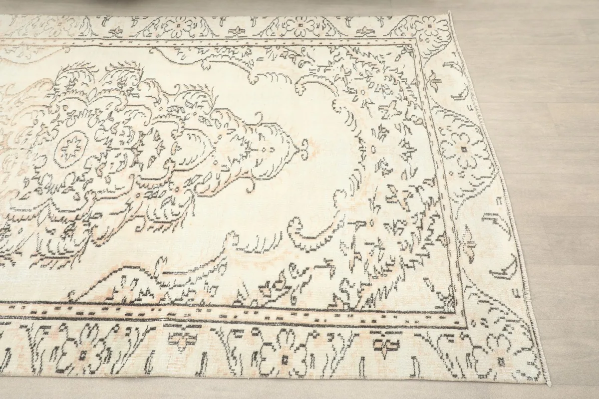 Close-up view of the rug's central medallion and surrounding charcoal and tan patterns