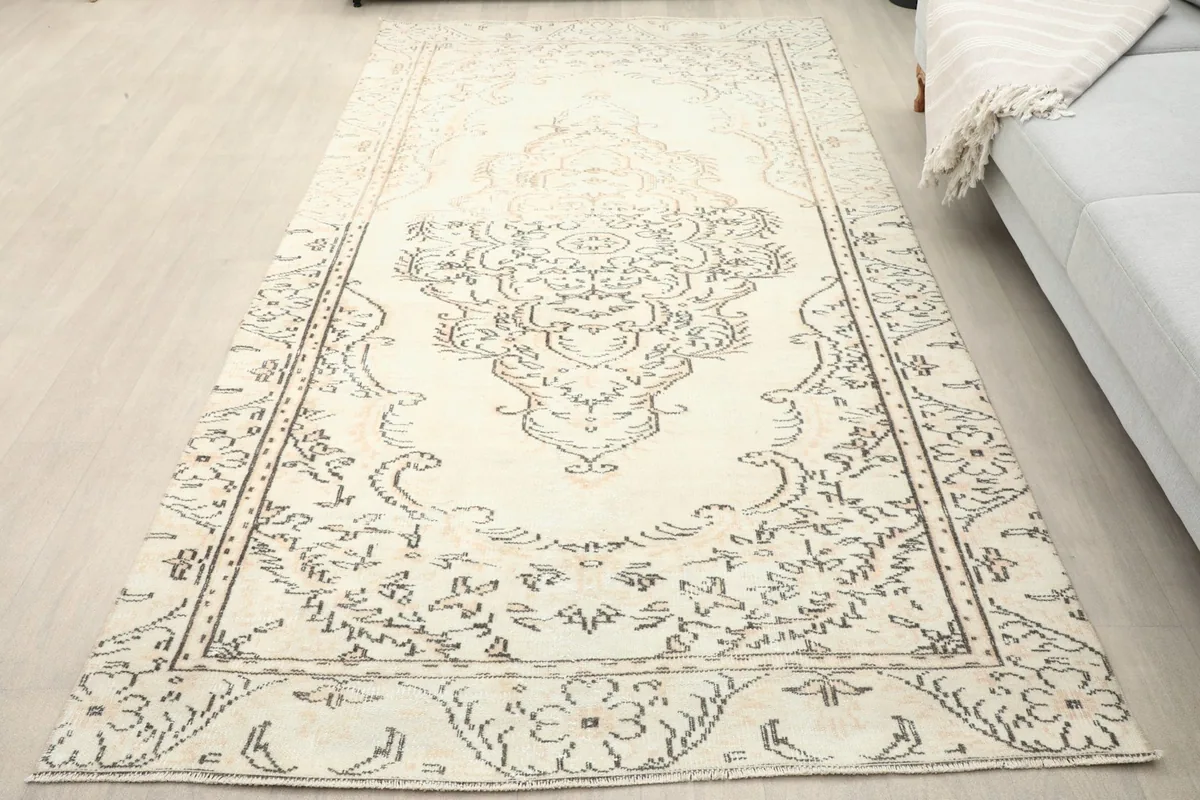 Overhead view of the vintage rug on a light floor, showing its full length and patterns