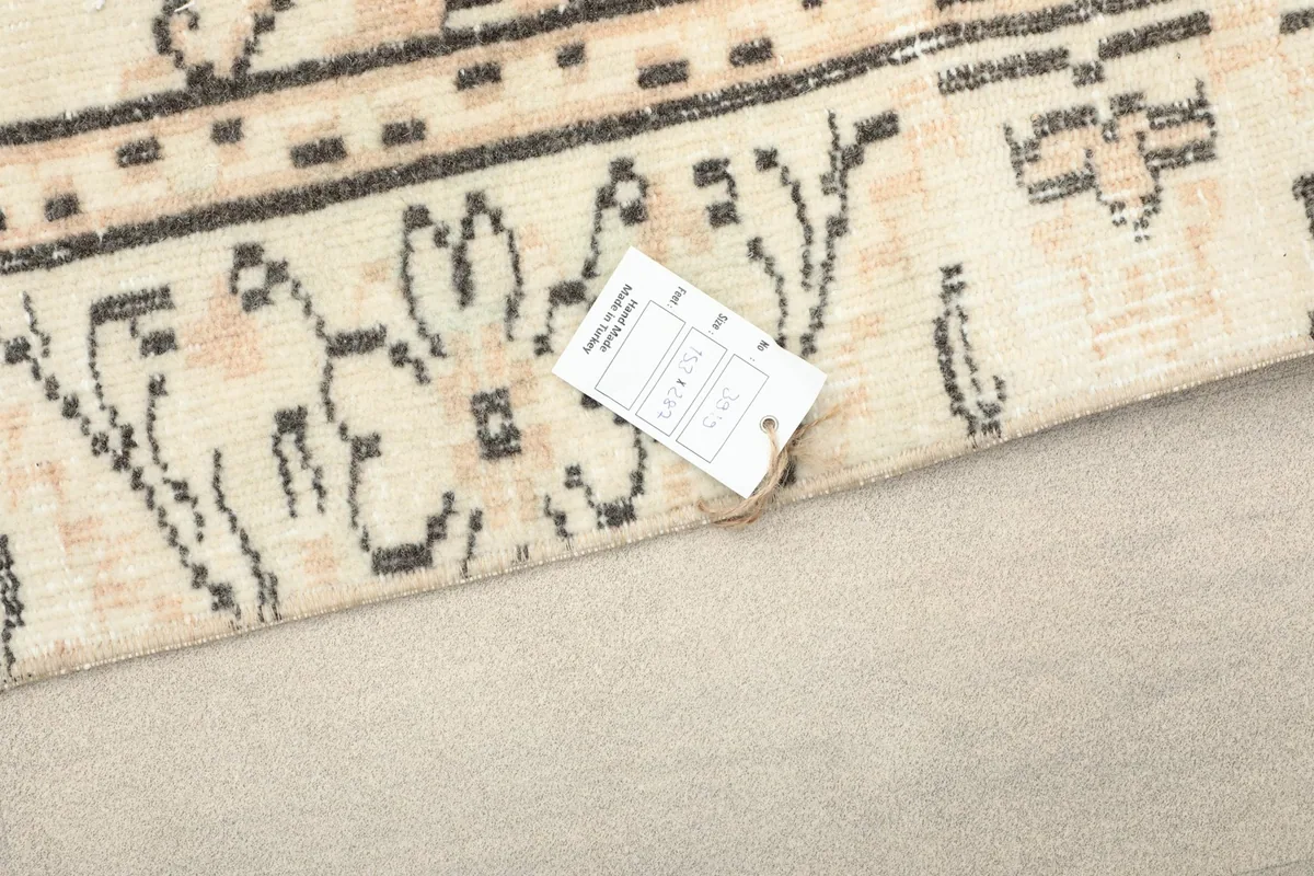 Detail of the rug's edge with a product tag, showing the weave and fringe
